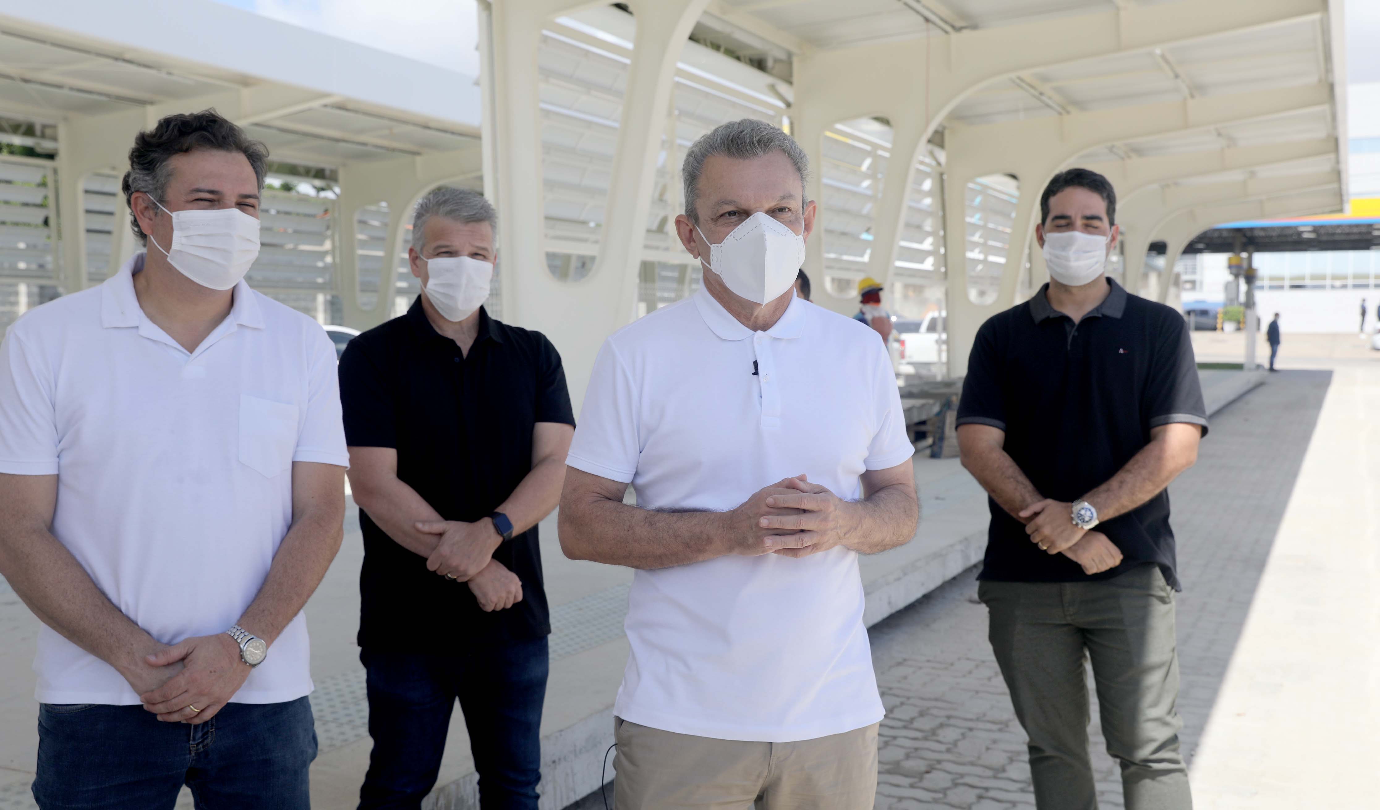 quatro pessoas com máscara posam para a foto tendo como fundo a obra do terminal aberto de passageiros